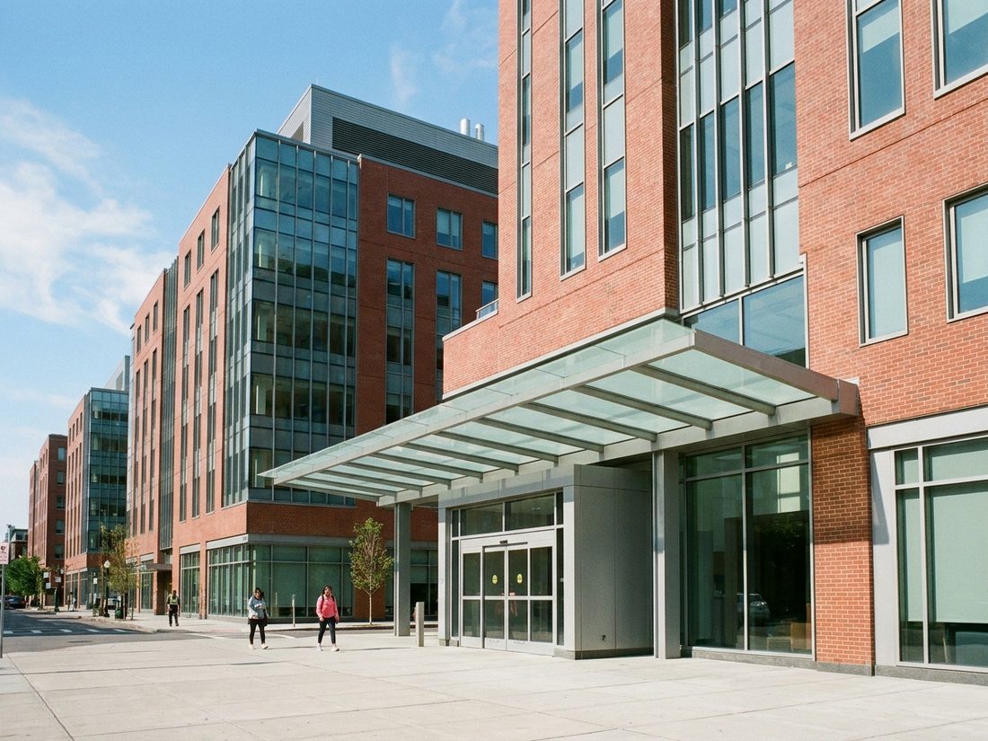 Drawing of a red-brick and glass hospital campus with a glass entrance canopy in the South End
